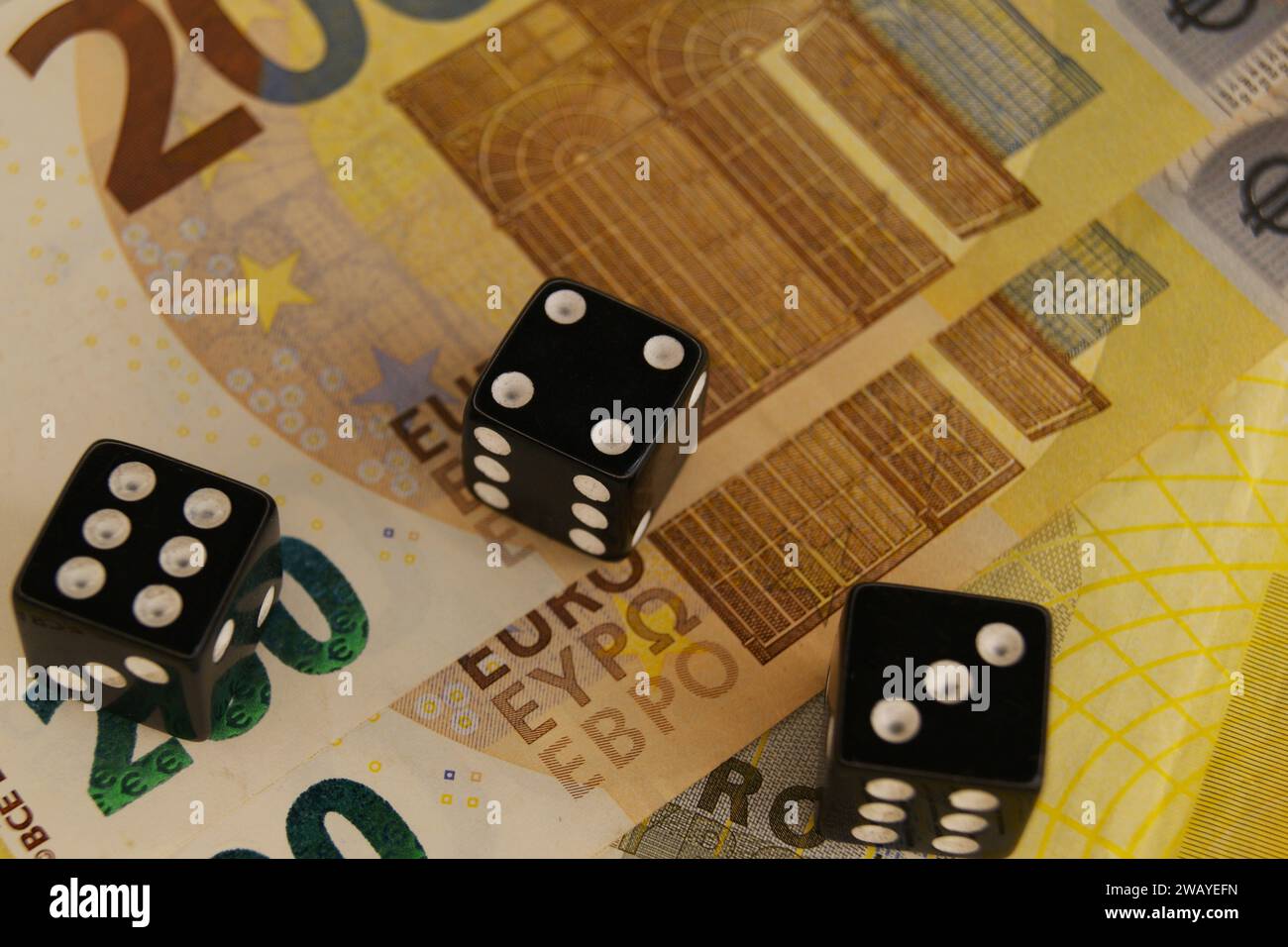 Three dice on new 200 euro banknotes, close up. Stock Photo