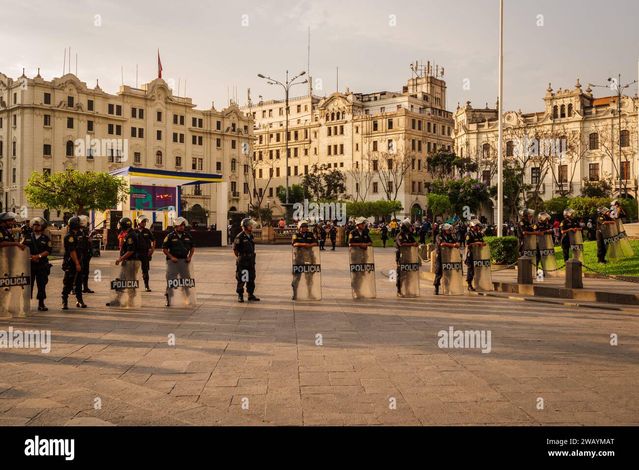 Lima, Peru--April 12, 2018.  Riot police  in Lima Peru stand ready with shields as they protesters watch nearby. Stock Photo