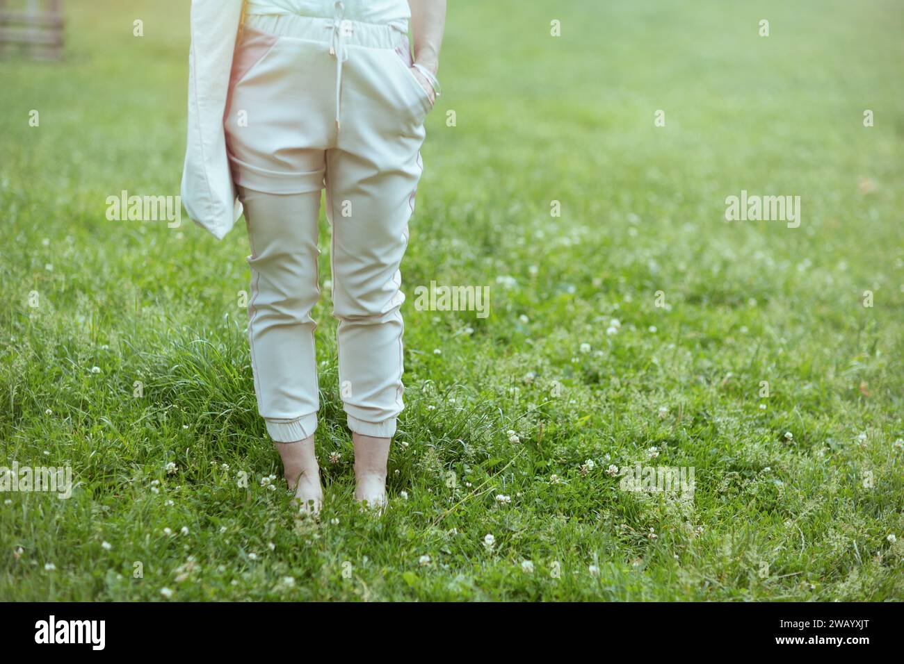Summer time. Closeup on woman in the meadow in the city park. Stock Photo