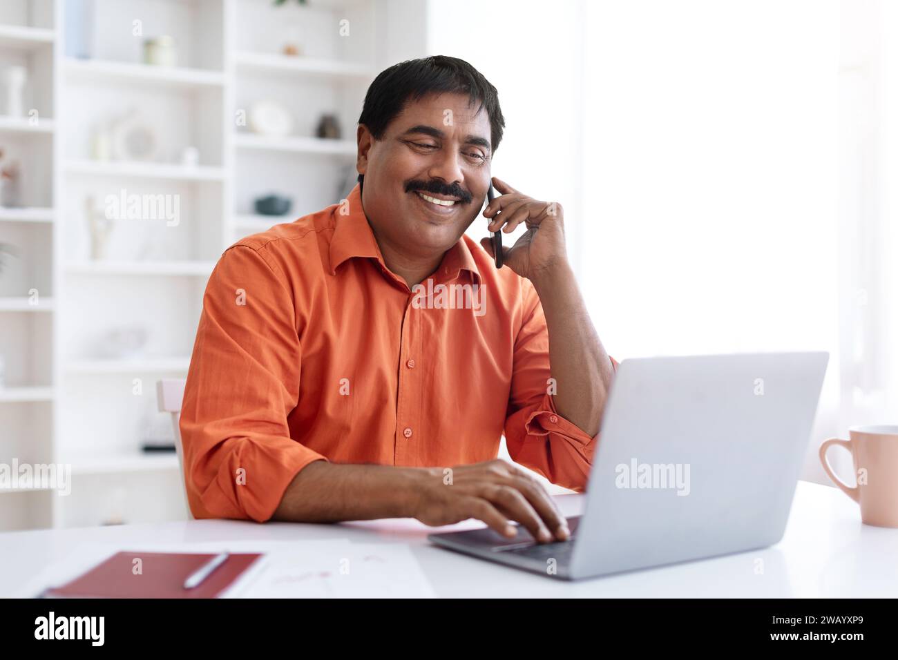 Middle aged eastern businessman talking on cellphone with client Stock Photo