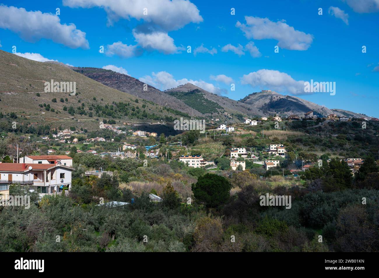 Panoramic view over the rough mountains with houses and blue sky around Cannizzaro- Favare, Sicily, Italy Stock Photo