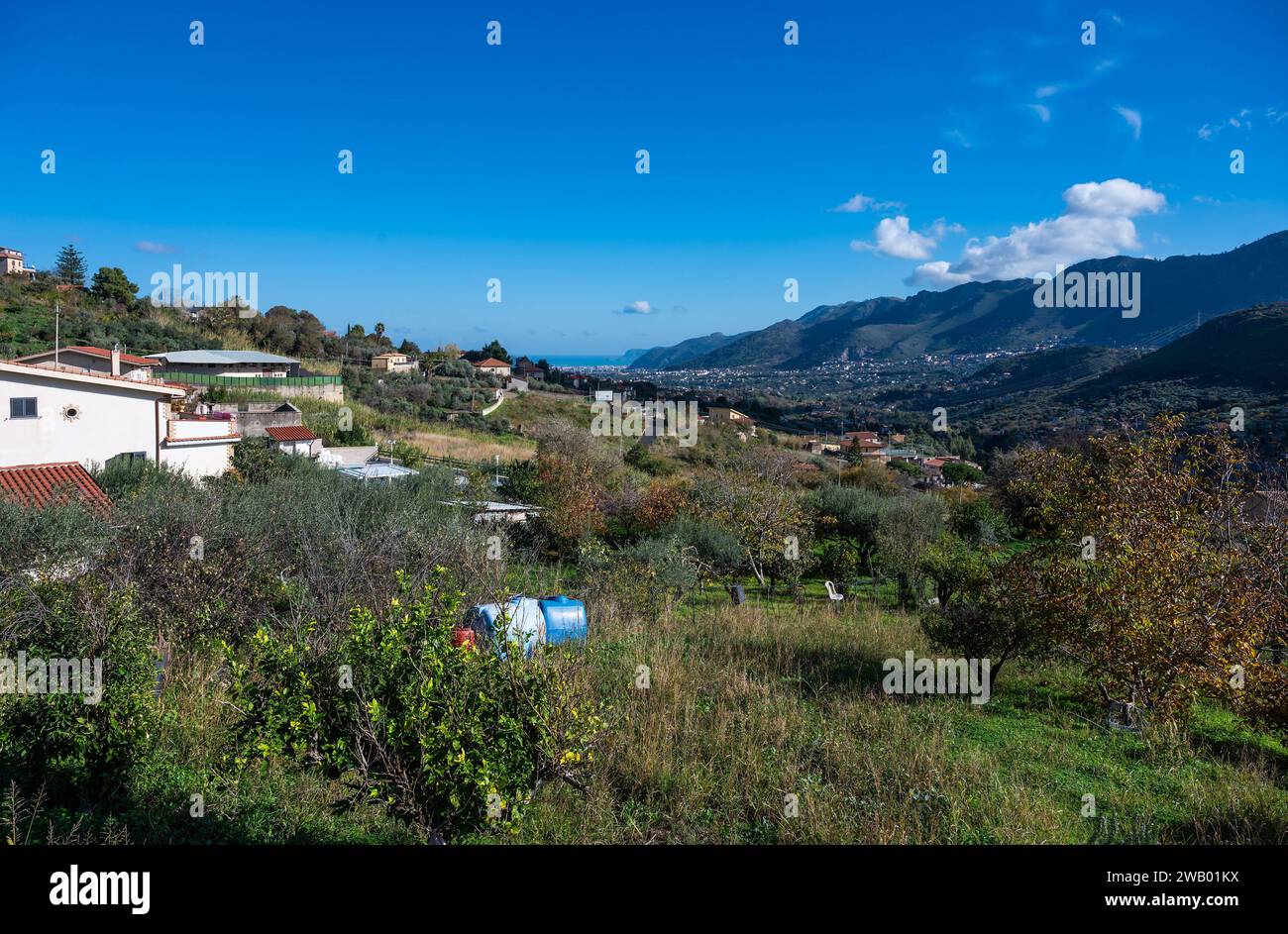 Panoramic view over the rough mountains with houses and blue sky around Monreale, Sicily, Italy Stock Photo