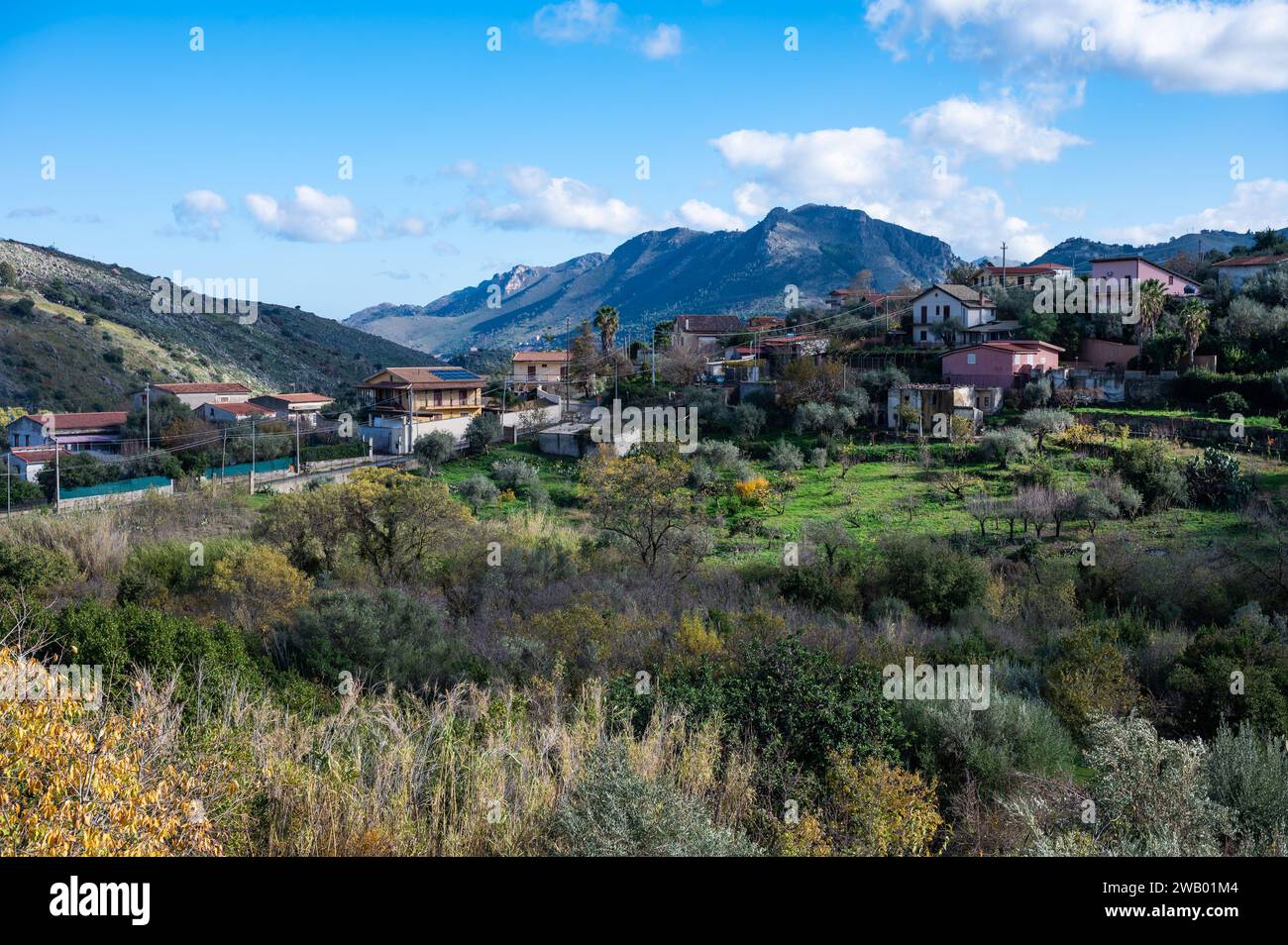 Panoramic view over the rough mountains with houses and blue sky around Cannizaro- Favare,, Sicily, Italy Stock Photo
