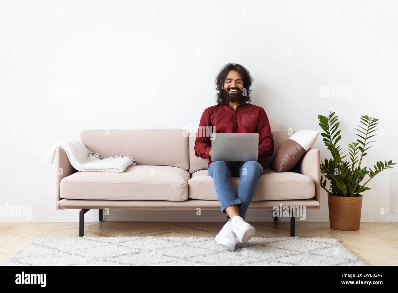 Handsome indian man using laptop at home Stock Photo
