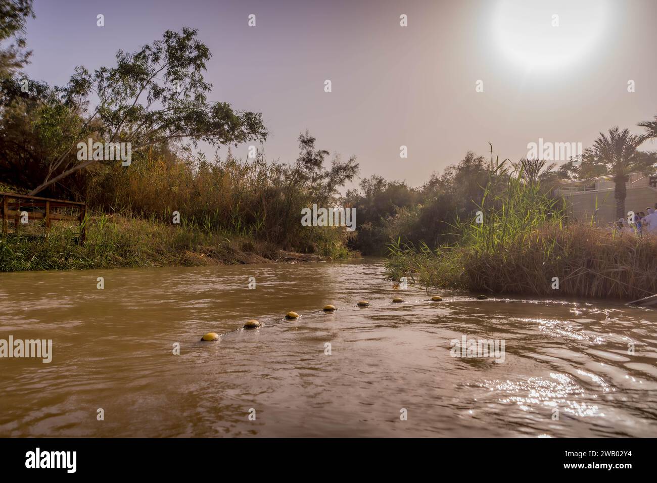 The muddy water of the Jordan river at the border between Palestine and Jordan during the sunset at Qasr al-Yahud, Jesus Christ baptismal site. Stock Photo