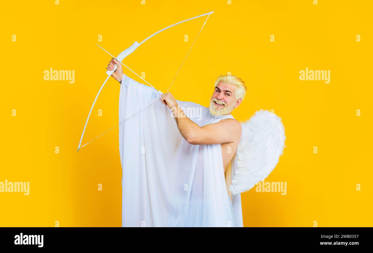 Love, passion, valentines day concept. Bearded man in angel costume with bow and arrows. Valentines day cupid in angel wings shooting arrows of love Stock Photo