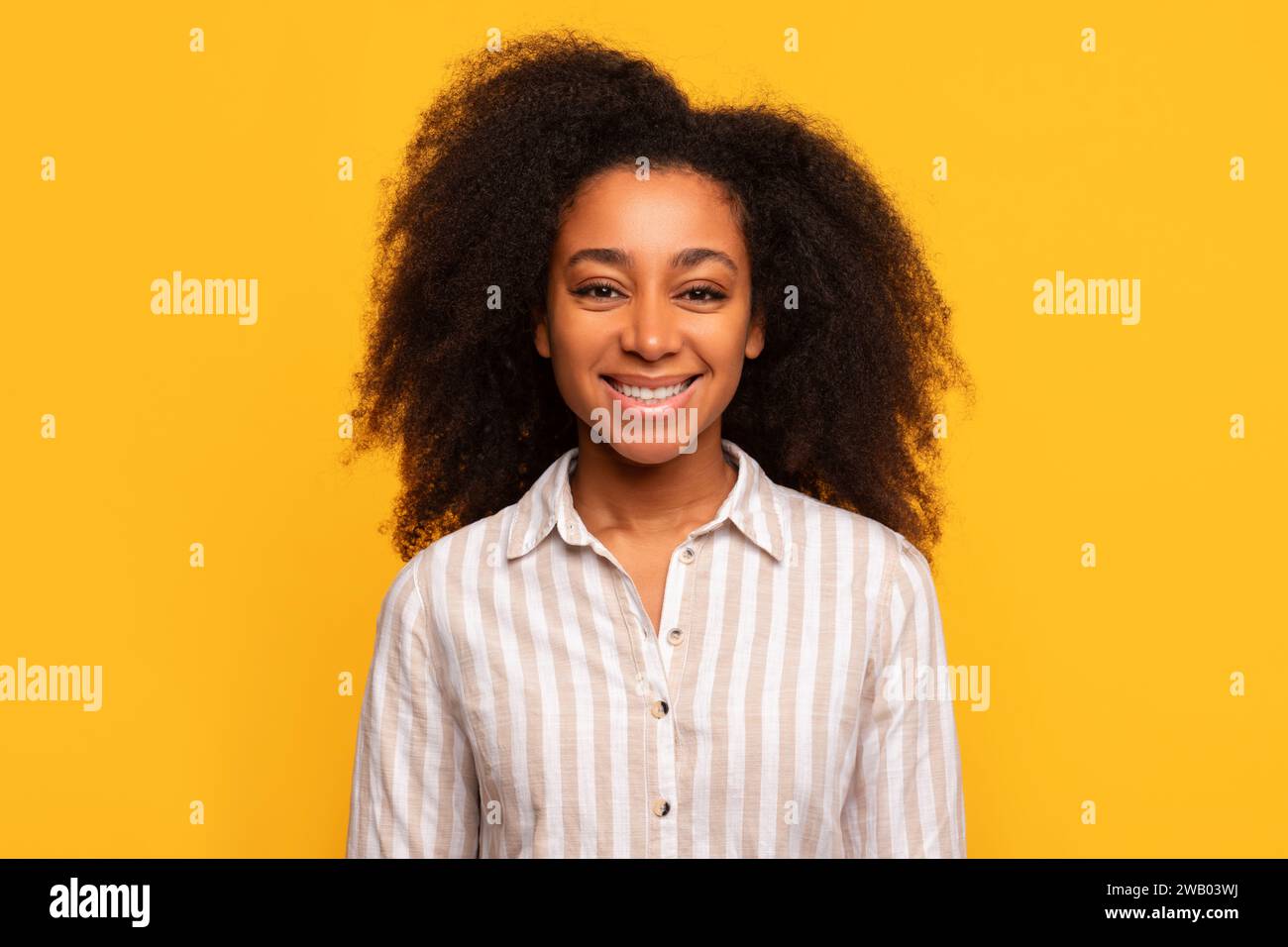 Happy african american lady smiling on yellow background Stock Photo