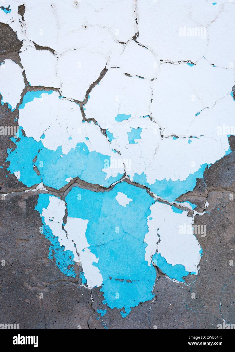 Abstract vertical background of shabby concrete wall surface with bright turquoise and white paint and weathered parts. Stock Photo