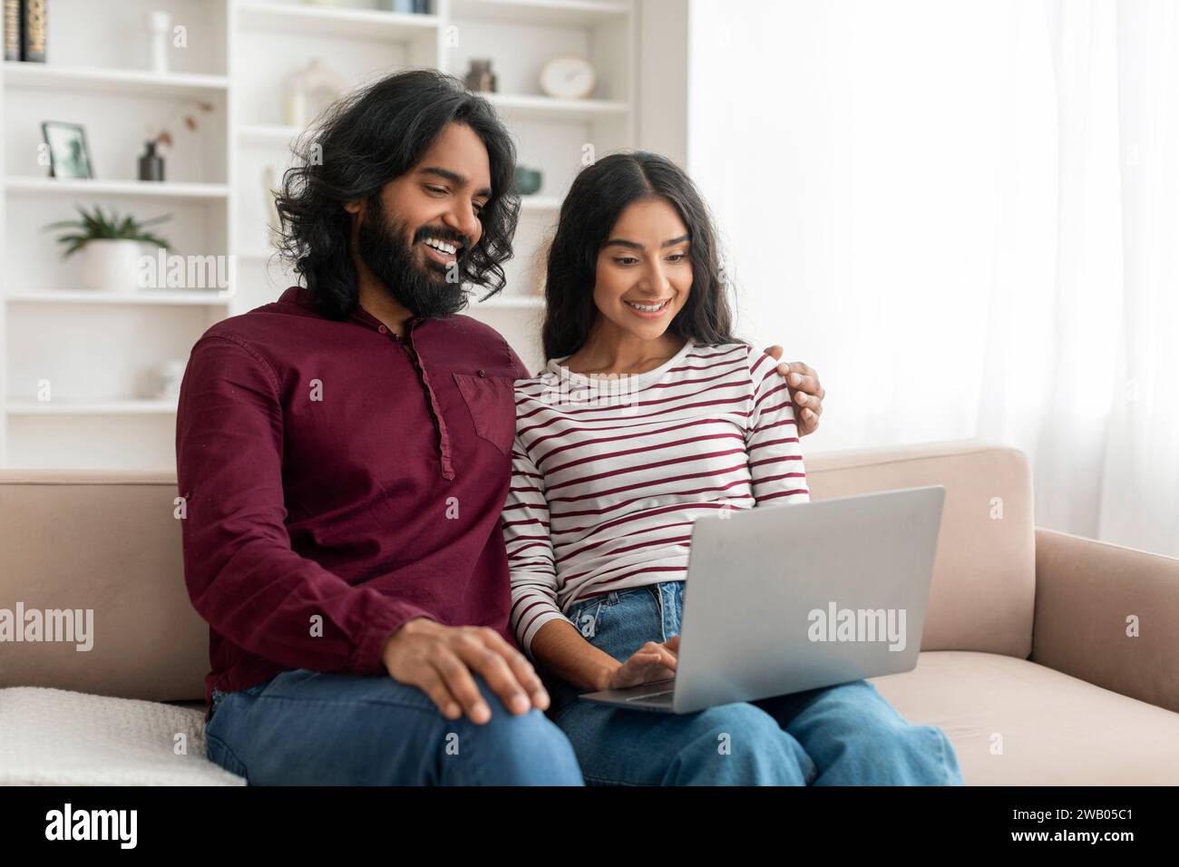 Cute young indian couple using computer at home Stock Photo - Alamy