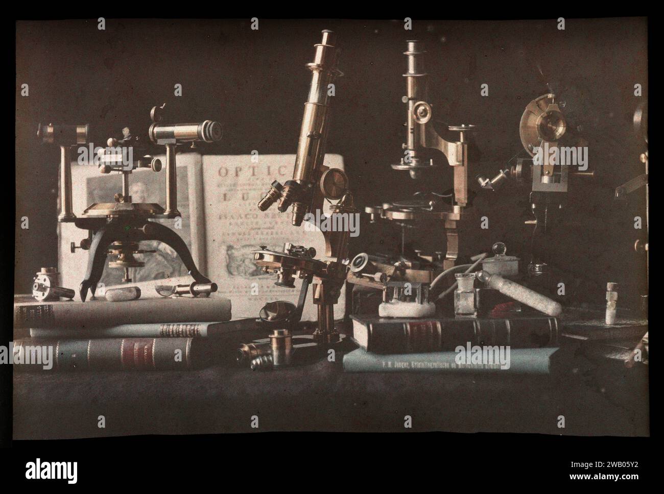 Still life with microscopes, books and an open edition of Isaac Newtons