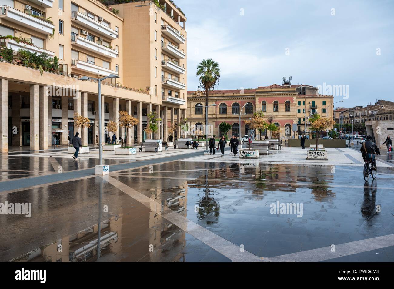 Palermo, Sicily, Italy, 15 December 2023 - The Vittorio Emanuele Orlando Square with restaurants and houses reflecting in the wet tiles Stock Photo