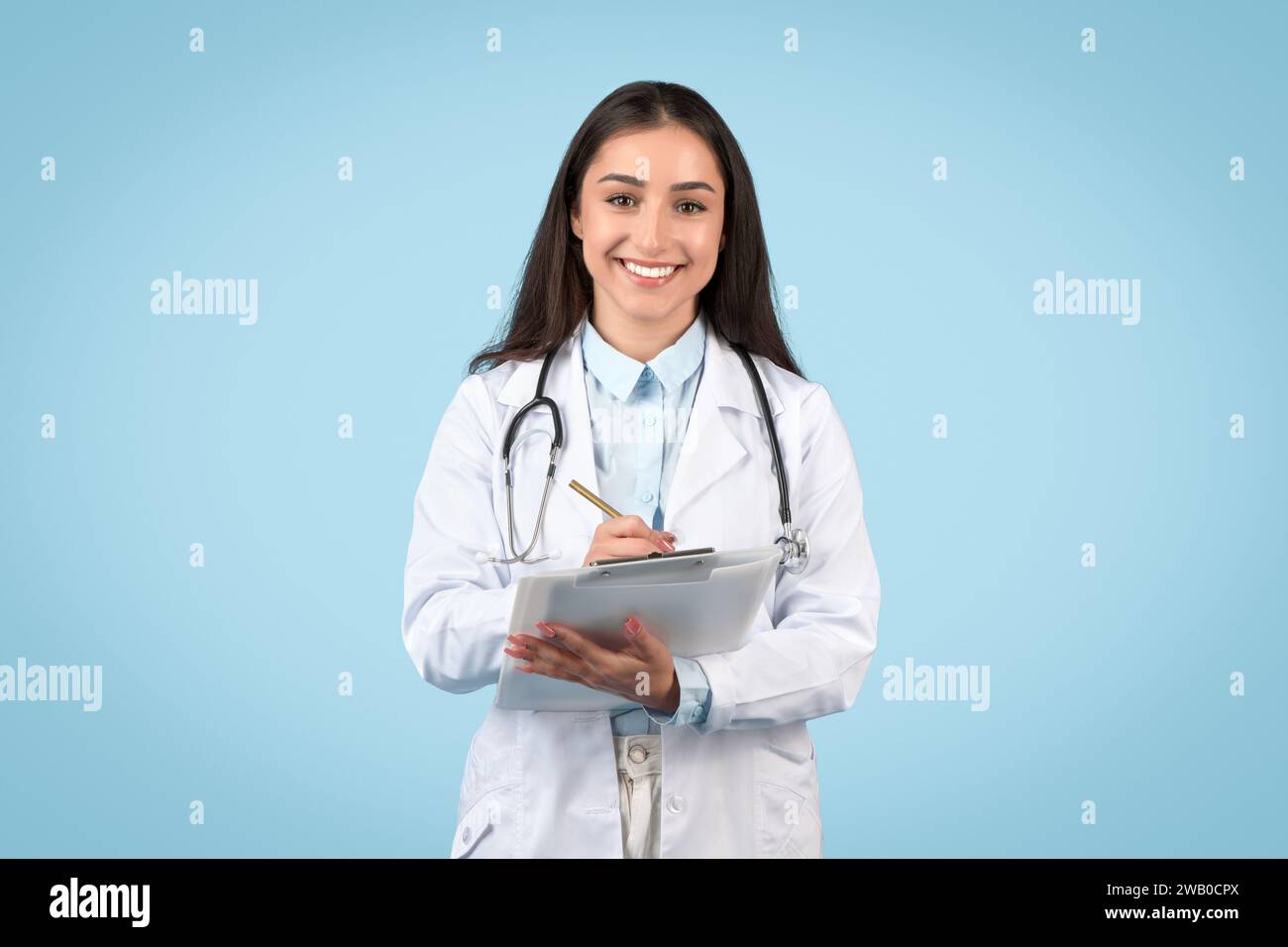 Happy female physician writing hi-res stock photography and images - Alamy