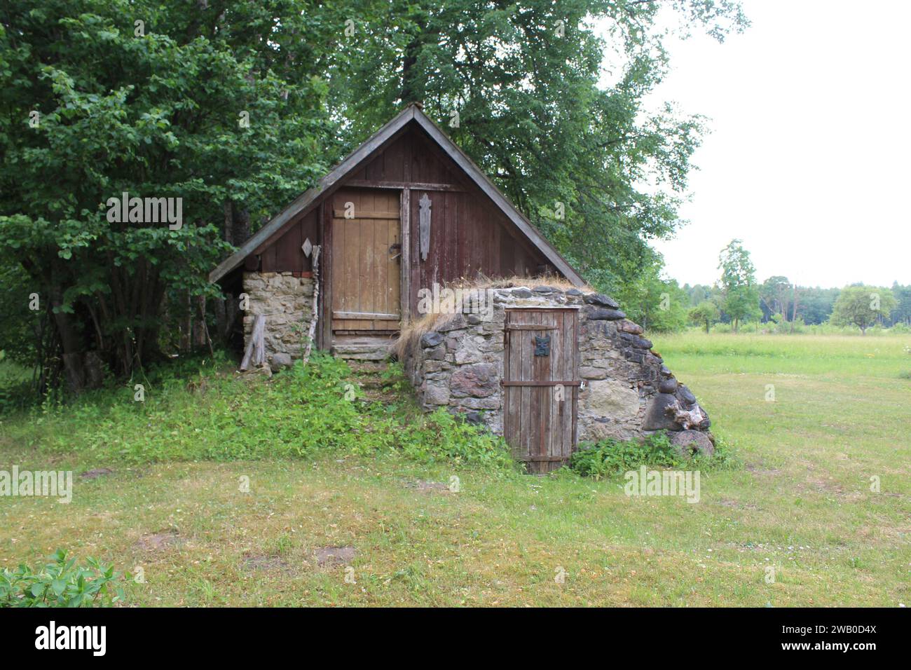 A-frame house in Sece, Latvia with a beet cellar in front of it Stock Photo