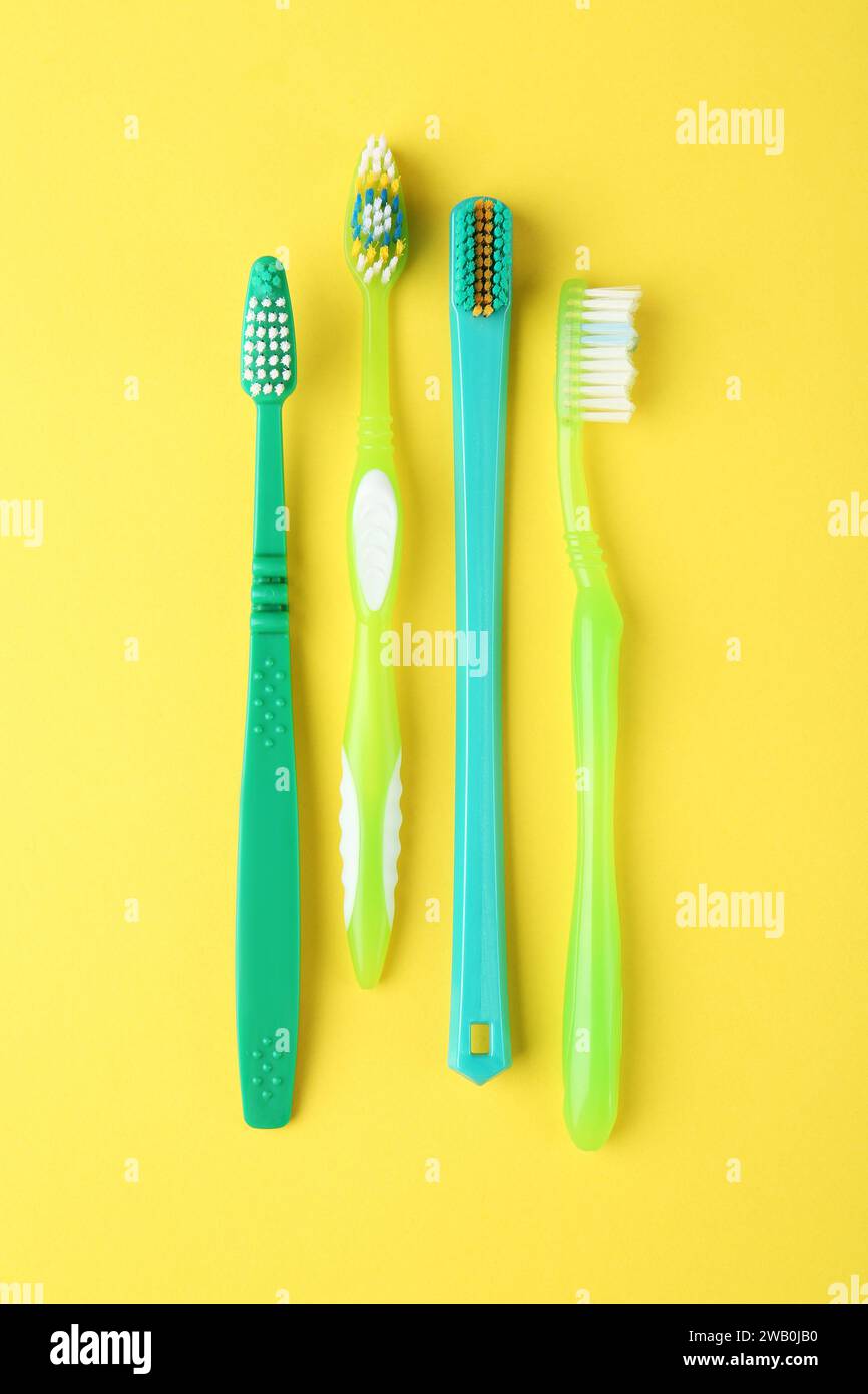 Different toothbrushes on yellow background, flat lay Stock Photo - Alamy