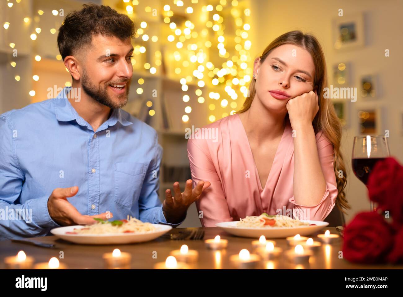 Man talking with hands, uninterested woman at dinner Stock Photo