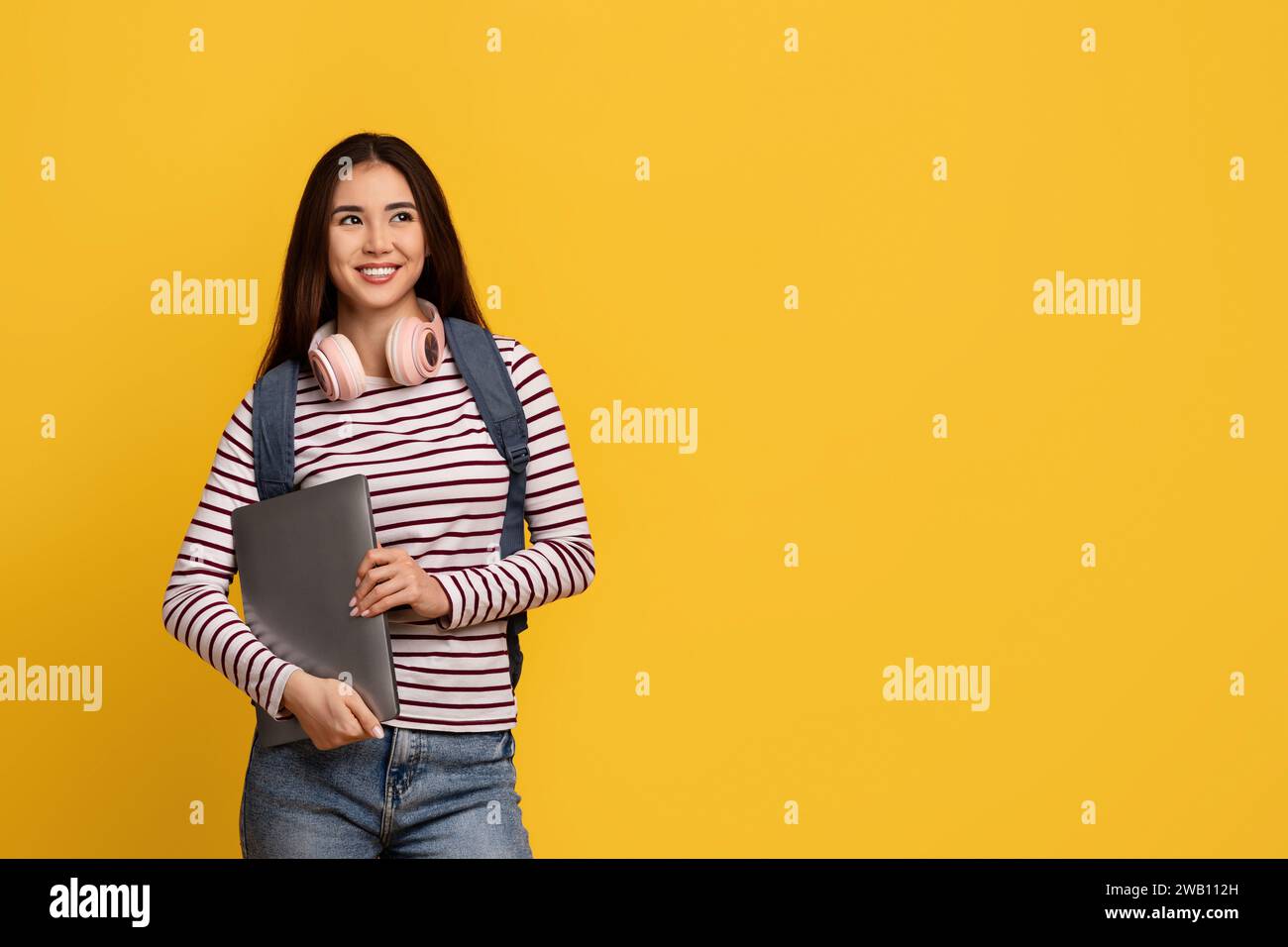 Happy young asian lady student holding laptop Stock Photo