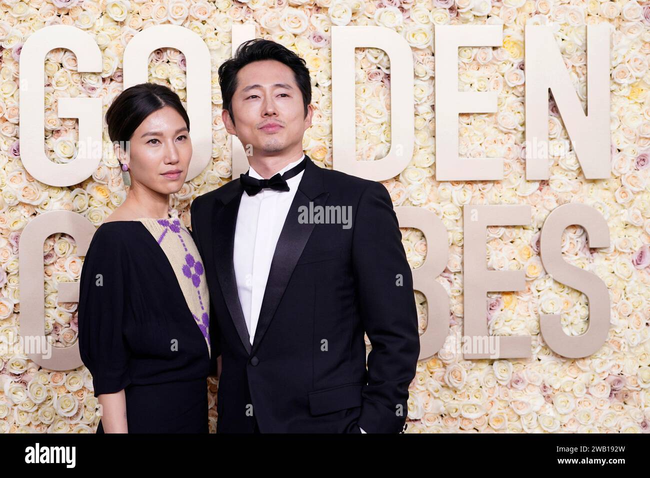 Joana Pak, left, and Steven Yeun arrive at the 81st Golden Globe Awards