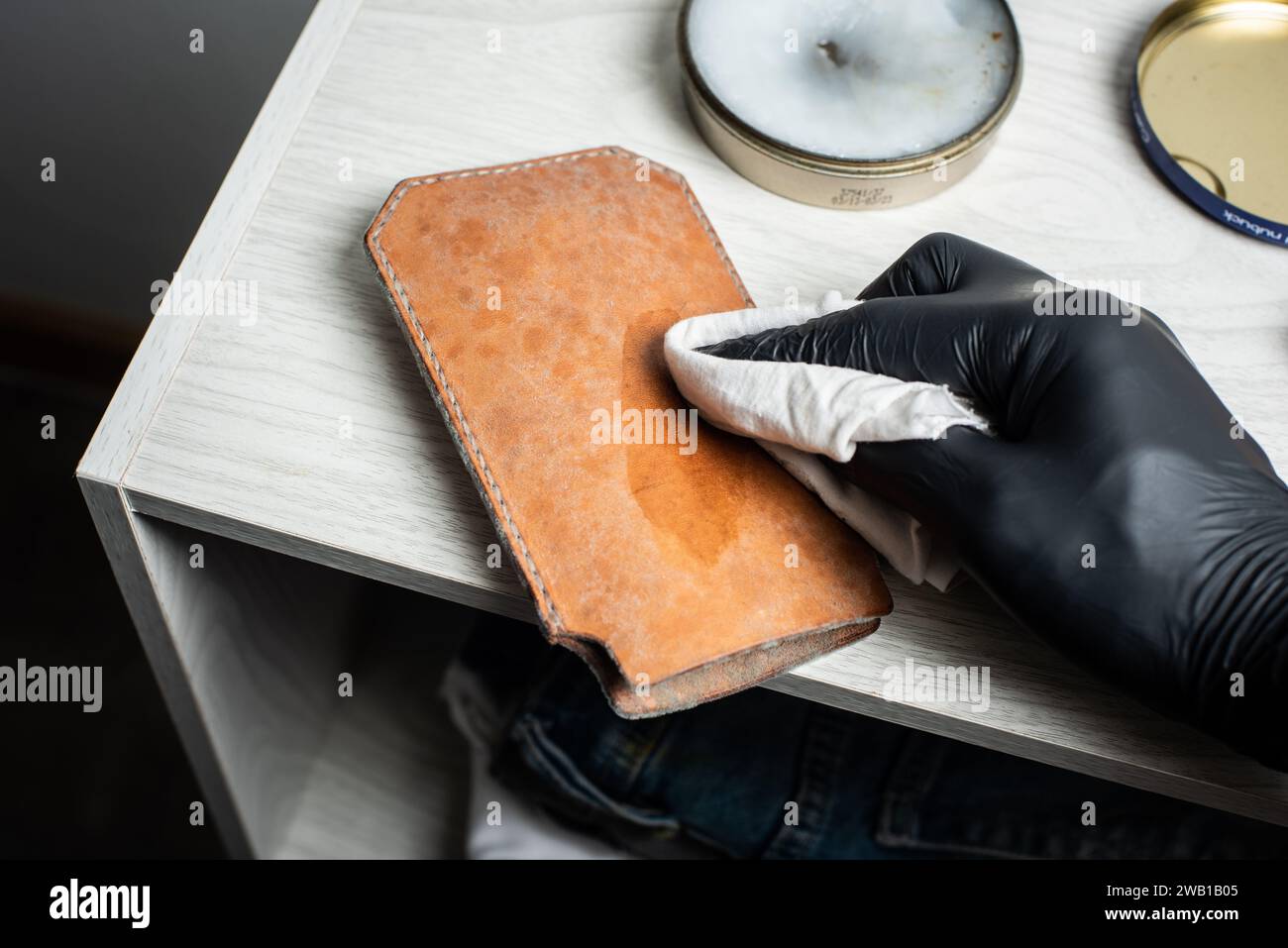 The man cleaning mould on leather product. Leather care concept. Stock Photo