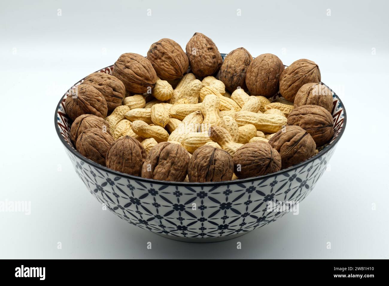 Walnuts and peanuts  in a bowl isolated on white background Stock Photo