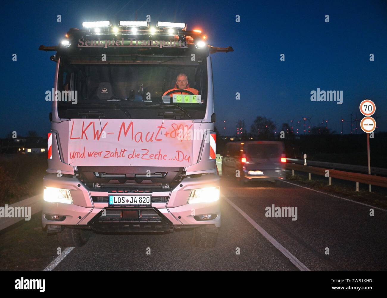 Jacobsdorf, Germany. 08th Jan, 2024. A haulage contractor is blocking the slip road onto the A12 freeway in the direction of Berlin with his truck and has a poster with the inscription 'Truck toll  80 percent and who pays the bill? You' on his vehicle. In response to the federal government's austerity plans, the farmers' association has called for a week of action with rallies and rallies starting on January 8. It is to culminate in a major demonstration in Berlin on January 15. Credit: Patrick Pleul/dpa/Alamy Live News Stock Photo