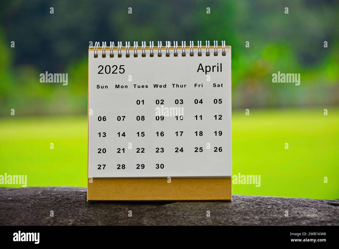 April 2025 white calendar with green blurred background New year