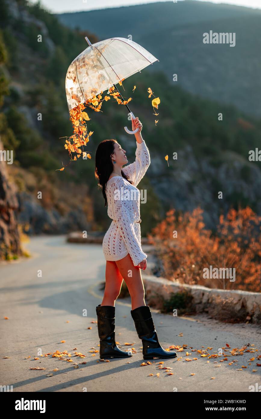 woman umbrella leaves , She holds him over her head, autumn leaves are falling  out of him. Beautiful woman in a dress with an umbrella in the autumn Stock  Photo - Alamy