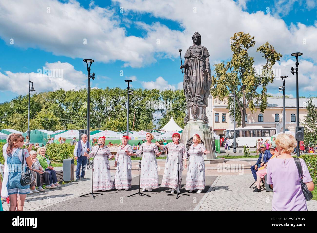 Irbit, Russia - August 11, 2023: Irbit Fair. Five mature women in concert dresses,vocal group, singing in front of audience on Lenin Square. Restored Stock Photo