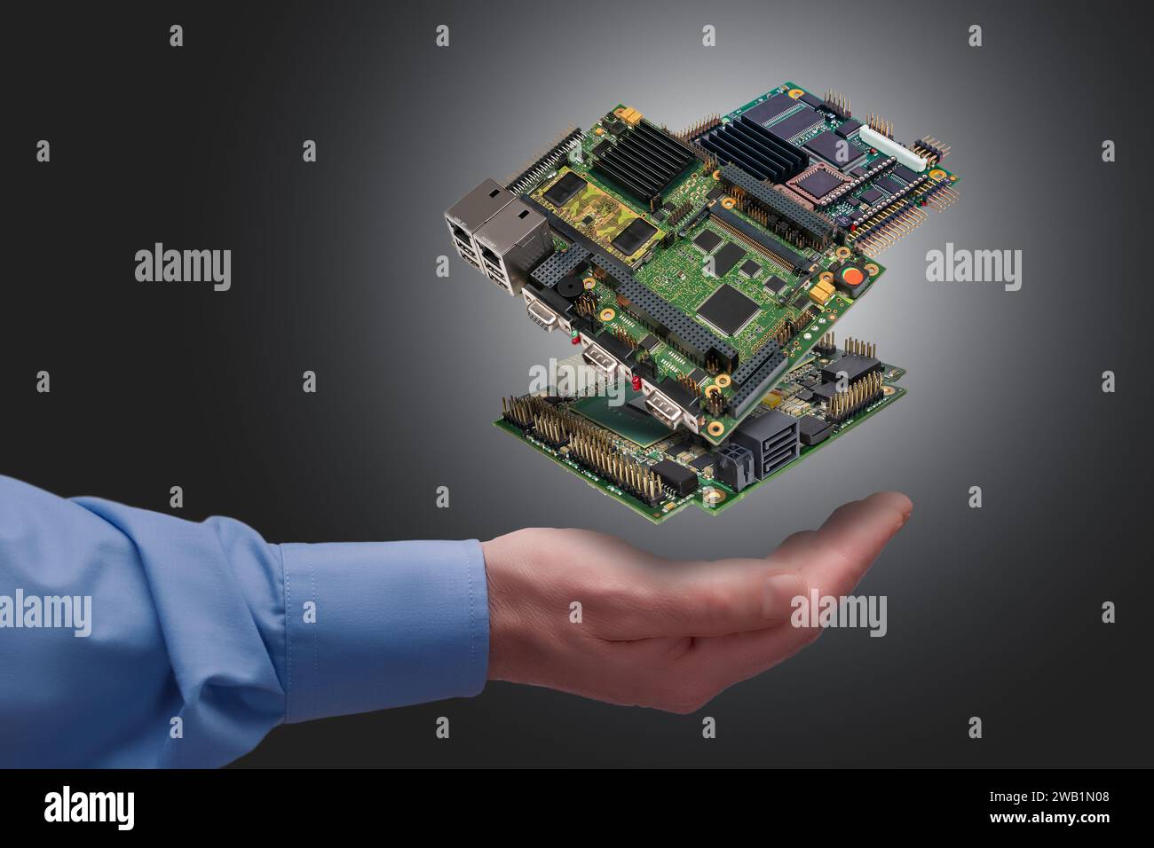 levitating industrial embedded CPU boards above man's hand on gray background Stock Photo