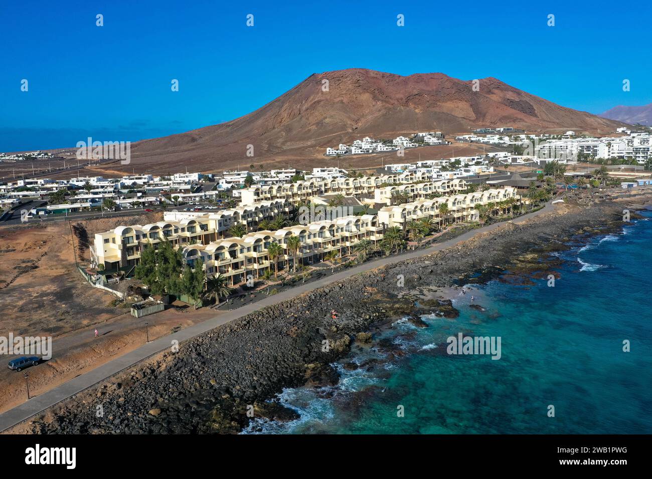 Playa Blanca coastline. Aerial drone panoramic view with Red volcano in the Background. Tourism and vacation concept. Flamingo beach  Lanzarote, Canar Stock Photo