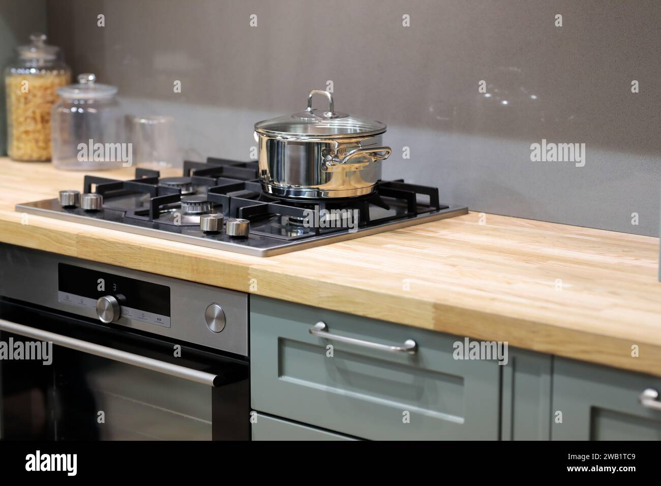 Wooden kitchen countertop with hob gas stove. Selective focus Stock