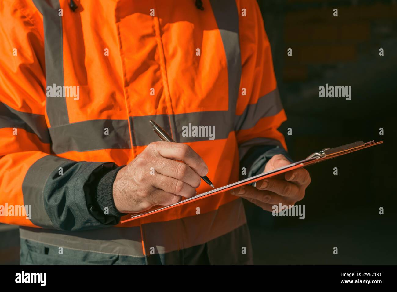 Architect and construction engineer making notes and remarks during building site inspection, selective focus Stock Photo