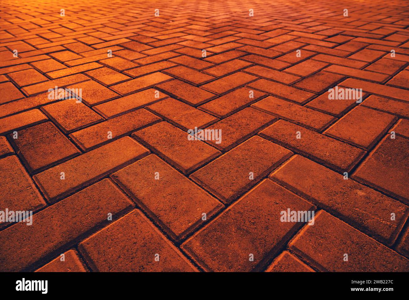 Texture of orange brick pavement in perspective as background. Selective focus. Stock Photo