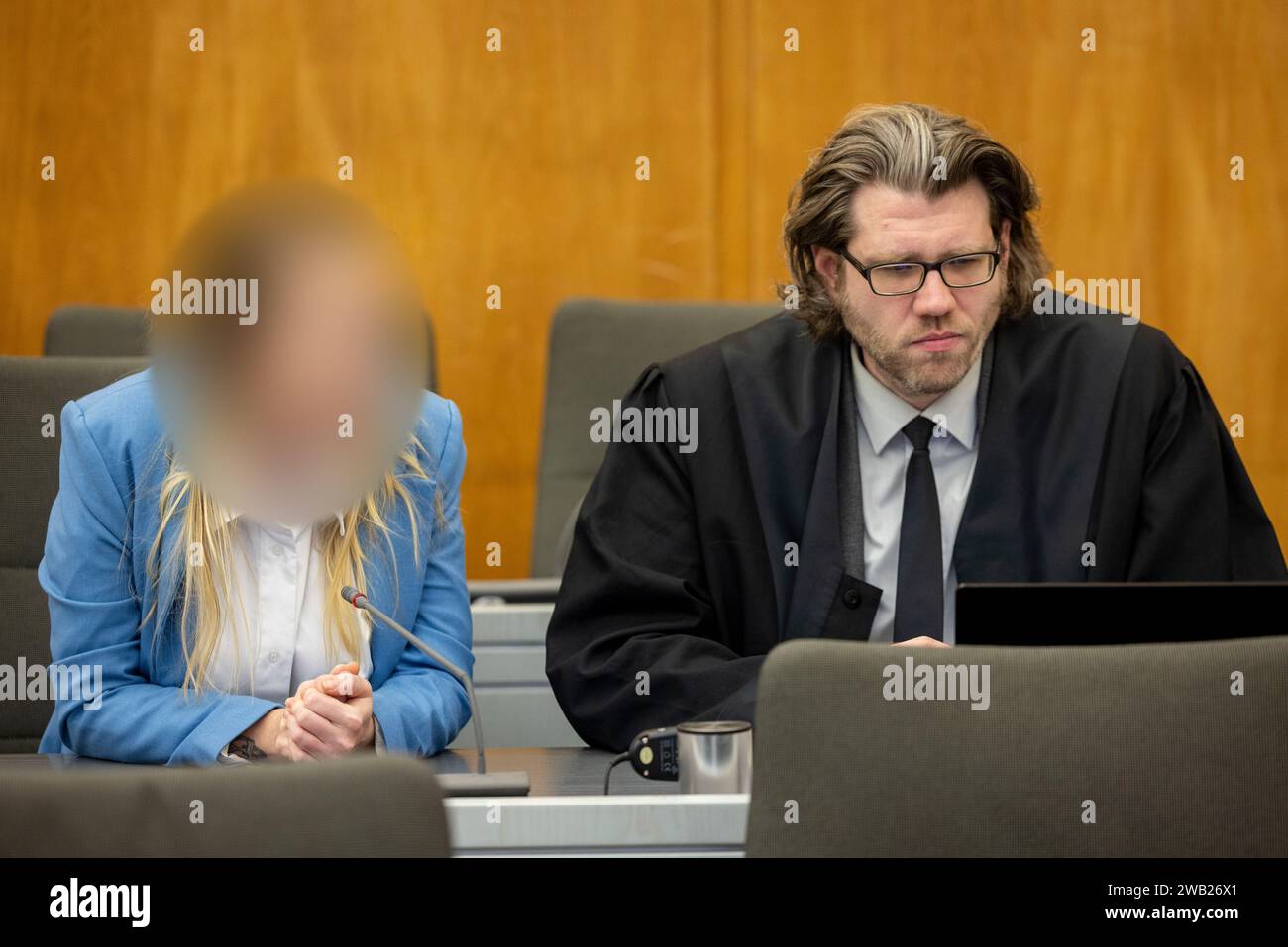 Essen, Germany. 08th Jan, 2024. The defendant sits next to her lawyer David Bleikamp in the courtroom. She is alleged to have given her grandmother two drinks in March and July 2023, which were allegedly laced with a high dose of sedatives. According to the indictment, the 31-year-old was after her grandmother's assets and inheritance. Credit: Christoph Reichwein/dpa - ATTENTION: Person was pixelated by order of the court for legal reasons/dpa/Alamy Live News Stock Photo