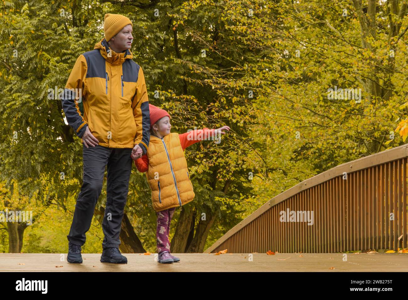 father and five-year-old daughter in fall park on bridge Stock Photo