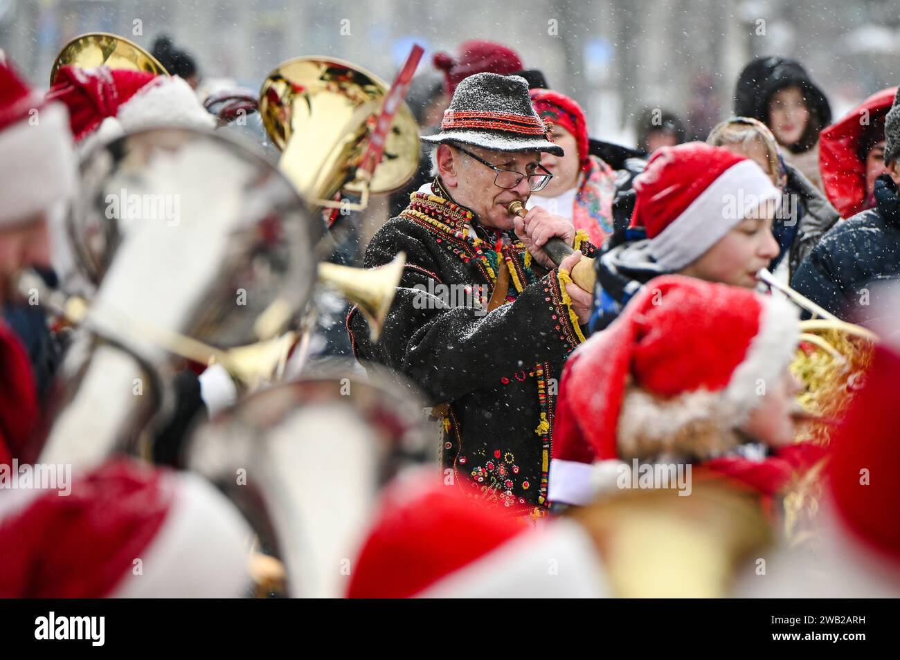 LVIV, UKRAINE - JANUARY 7, 2024 - A senior man blows a horn during the New Joy Has Come. Rozkoliada, a Ukrainian winter folklore festival, Lviv, weste Stock Photo