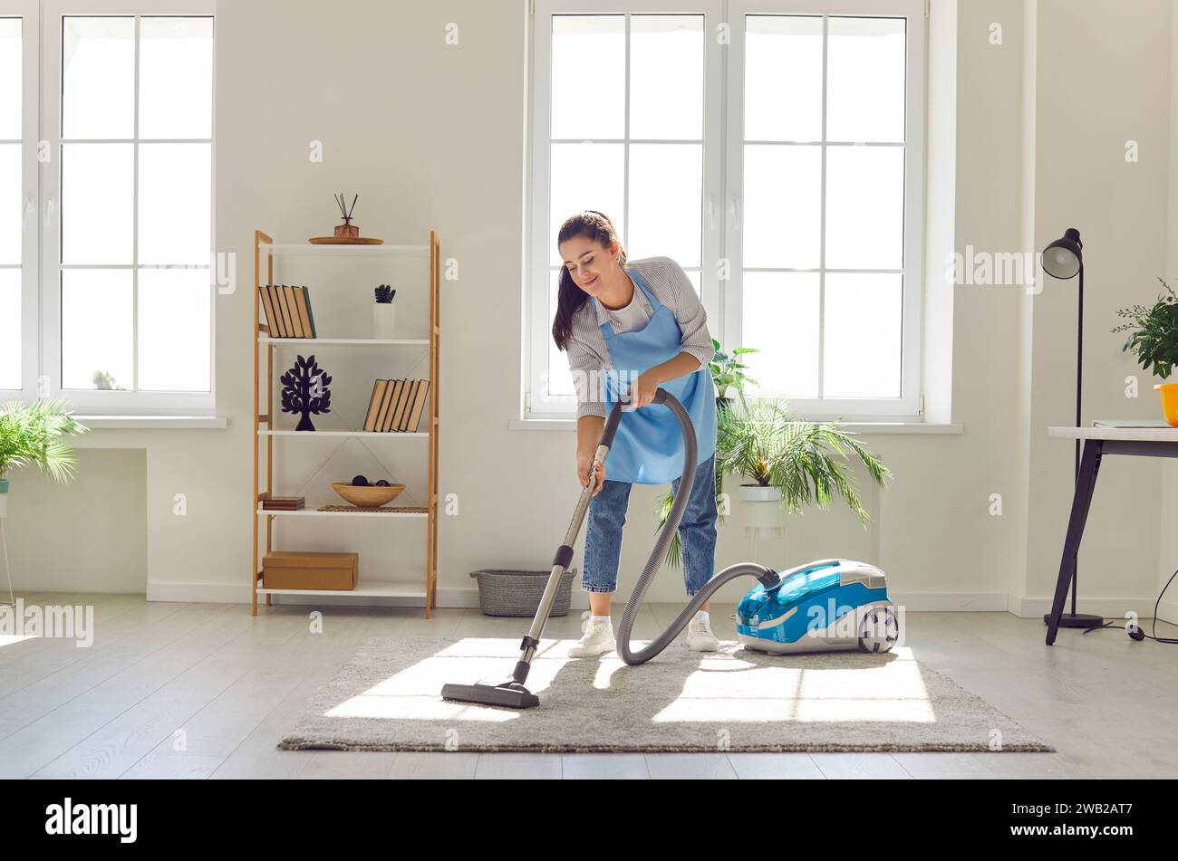 Woman Vacuuming the Living Room Carpet Stock Photo - Alamy