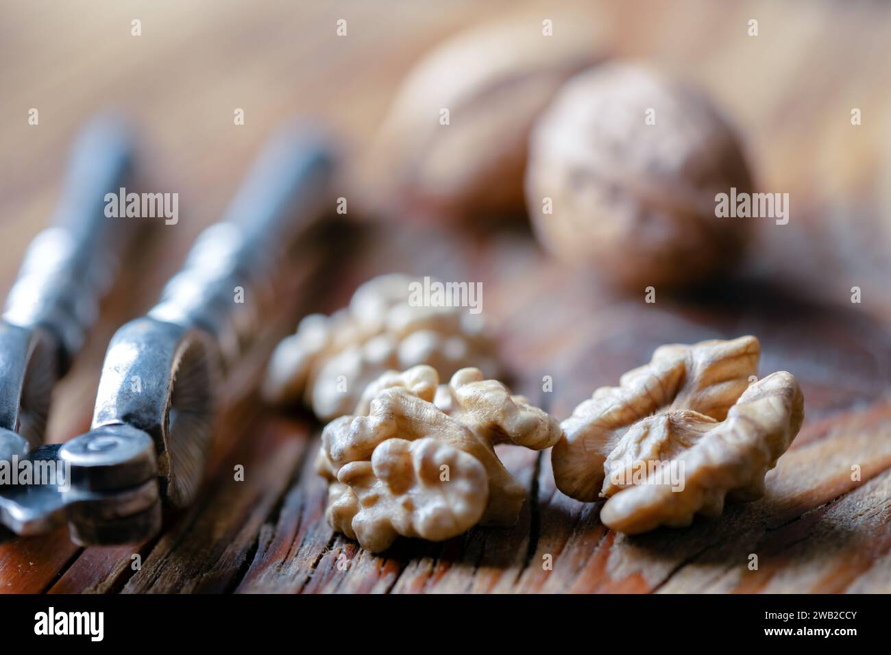 Walnut nut kernels with a vintage silver nut cracker close up. Food photography Stock Photo
