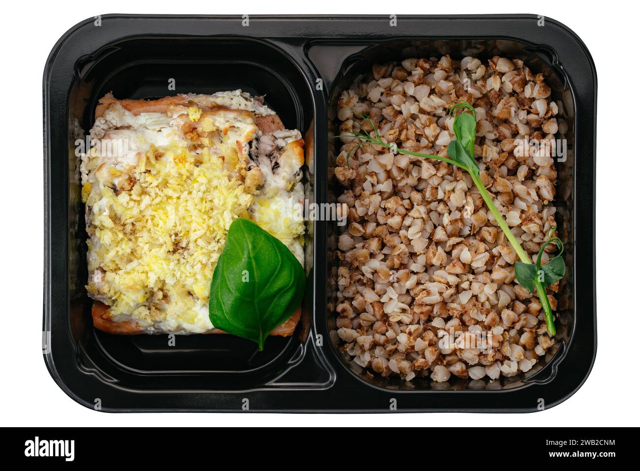 buckwheat with baked fish in lunch box on white background Stock Photo