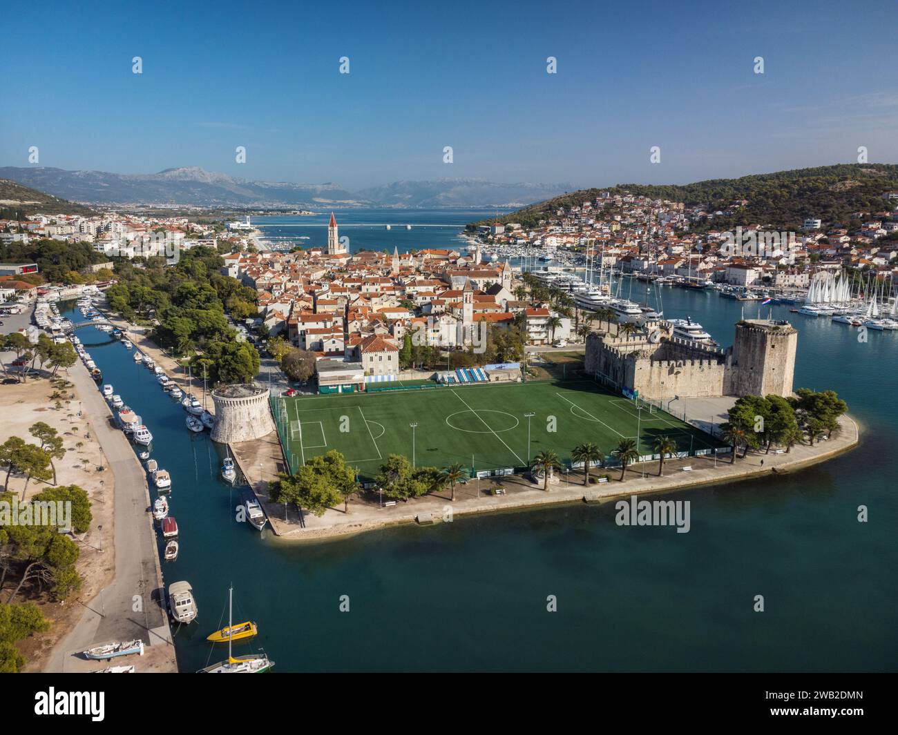 Aerial of football pitch and Trogir old town with surrounding harbor Stock Photo