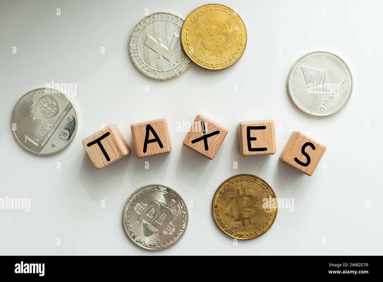 TAXES - word on wooden cubes on the background of coins and calculator. Business and finance concept Stock Photo