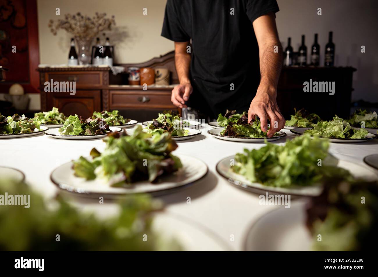 Unrecognisable man preparing salads during a gastronomic event. Stock Photo