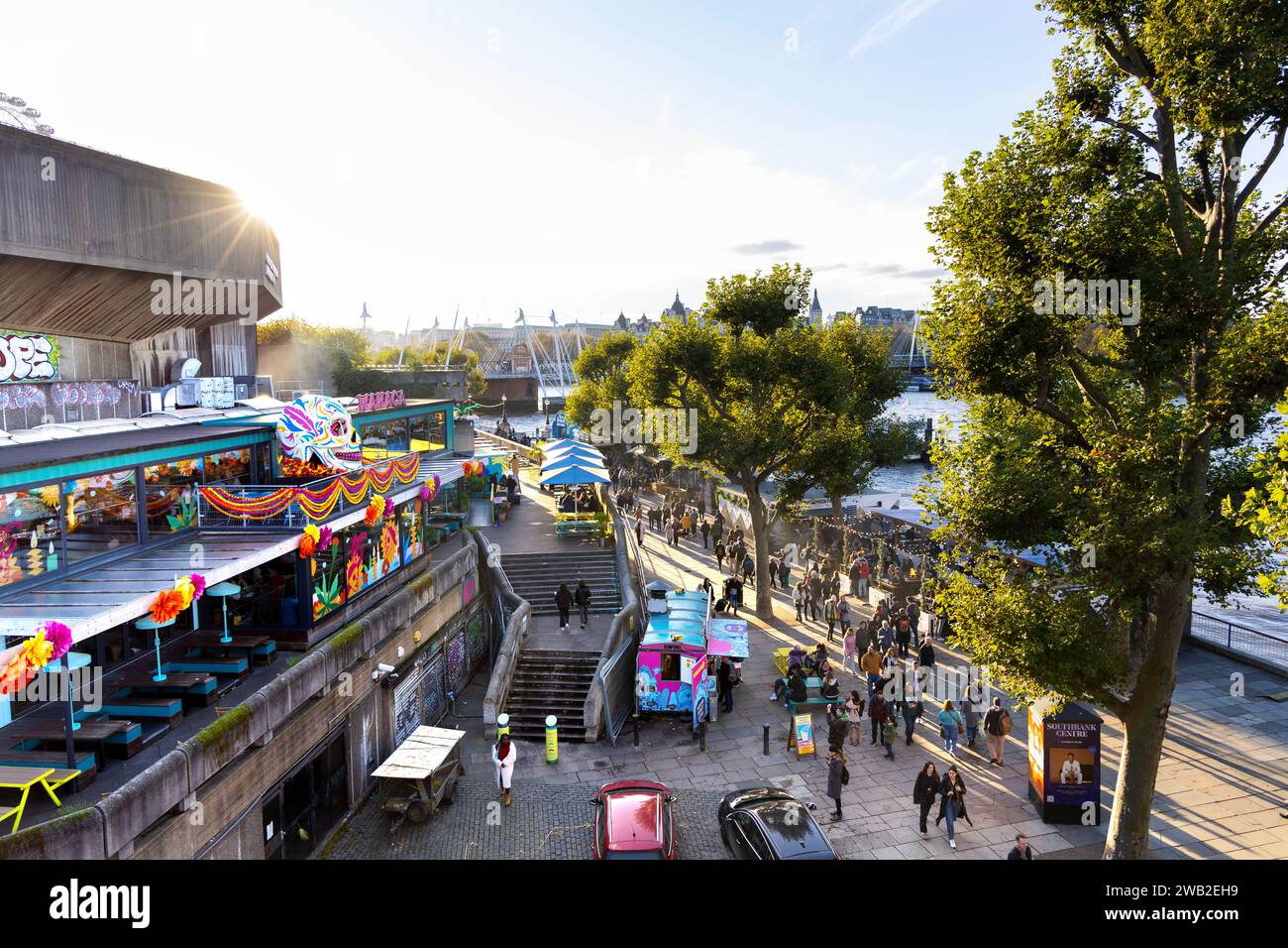 People walking down the Southbank with brutalist Southbank Centre on the left, London, England Stock Photo