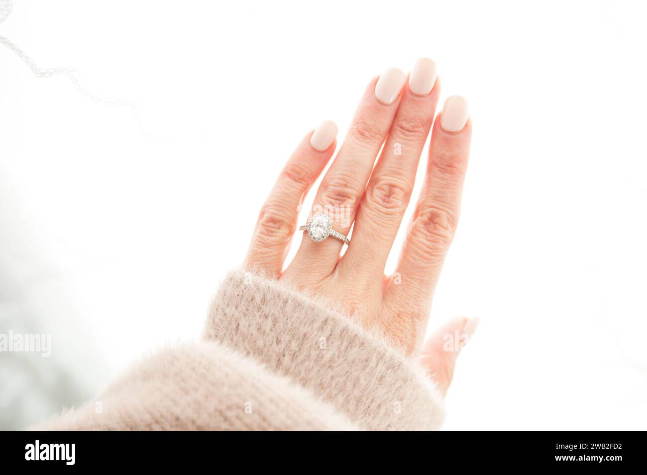 Oval Diamond Ring on Woman's Manicured Hand Stock Photo