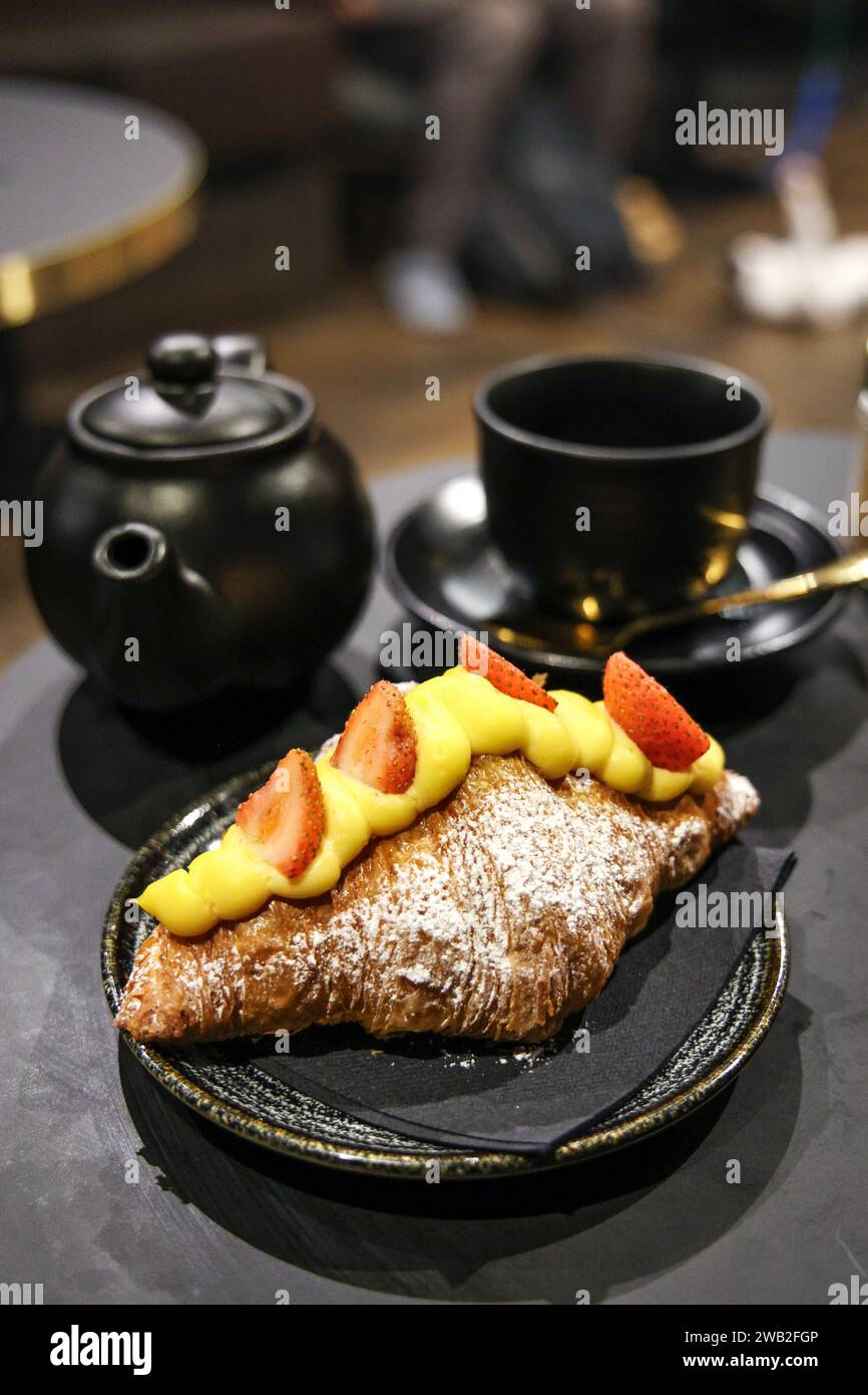 Croissant with strawberries at with tea at Java Whiskers Cat Cafe, London, England Stock Photo