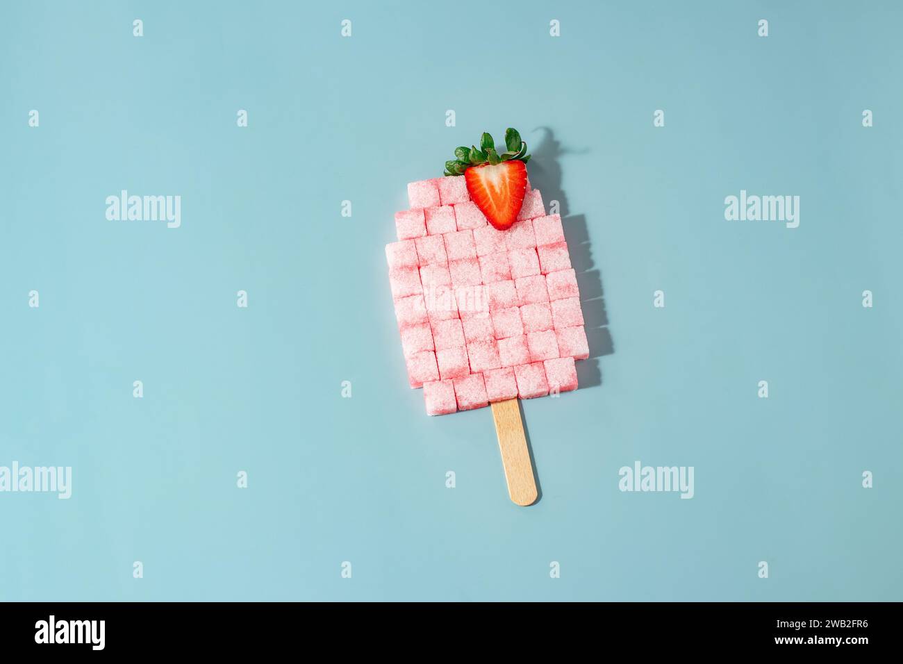 Strawberry Sugar Cube Popsicle on Blue Background Stock Photo