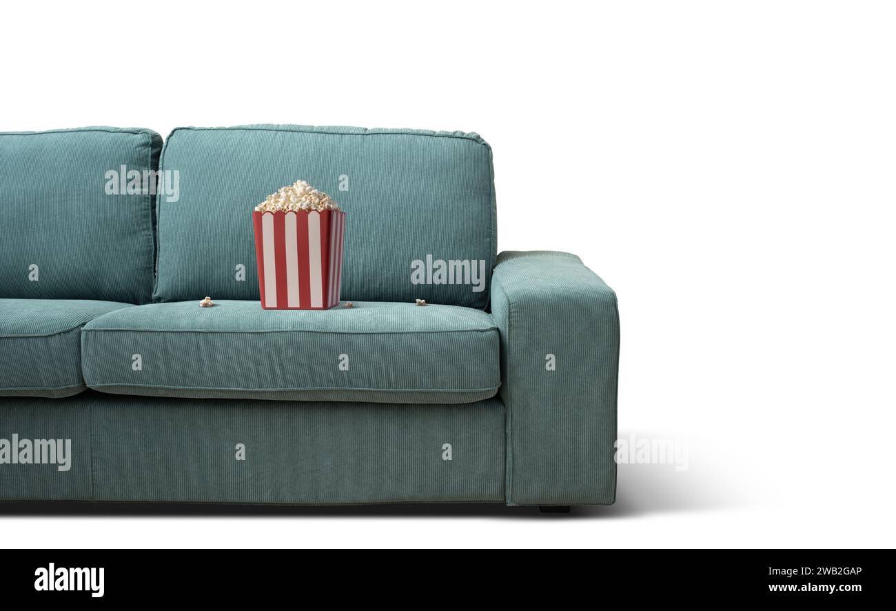 Popcorn box on the couch: TV, movies and entertainment concept Stock Photo