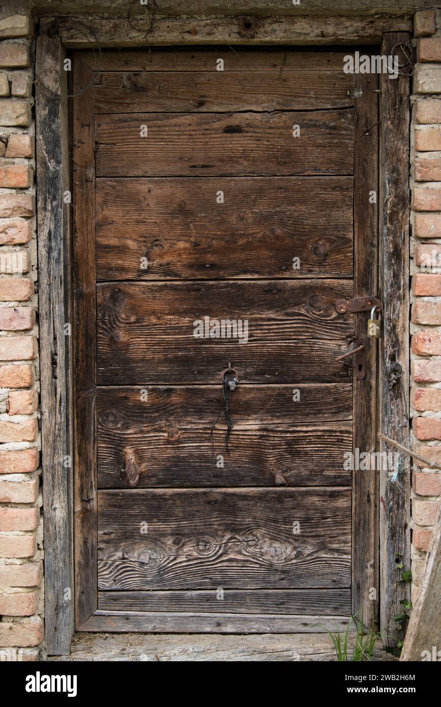 Sunja, Croatia, 05,04,2021: Old wooden rustic door on rural home wall. Stock Photo