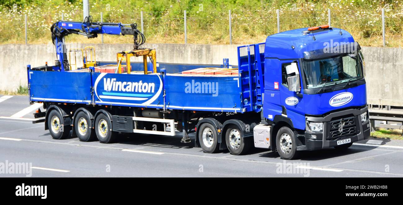 Wincanton logistics business lorry truck towing loaded articulated trailer hydraulic crane offload equipment driving on M25 motorway Essex England UK Stock Photo