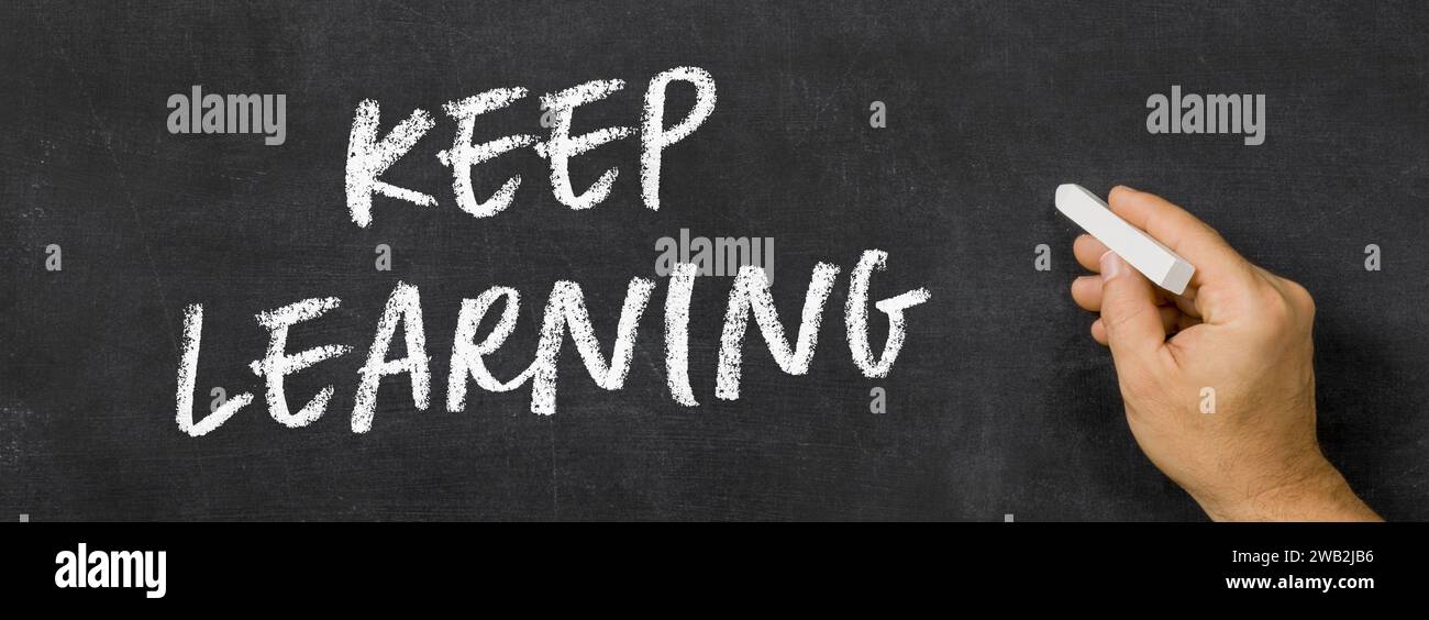 Text written on a blackboard -  Keep learning Stock Photo