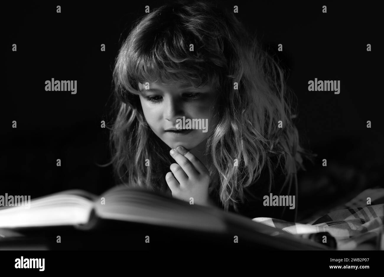 Happy childhood, dreaming child. Child reading a book in bed before
